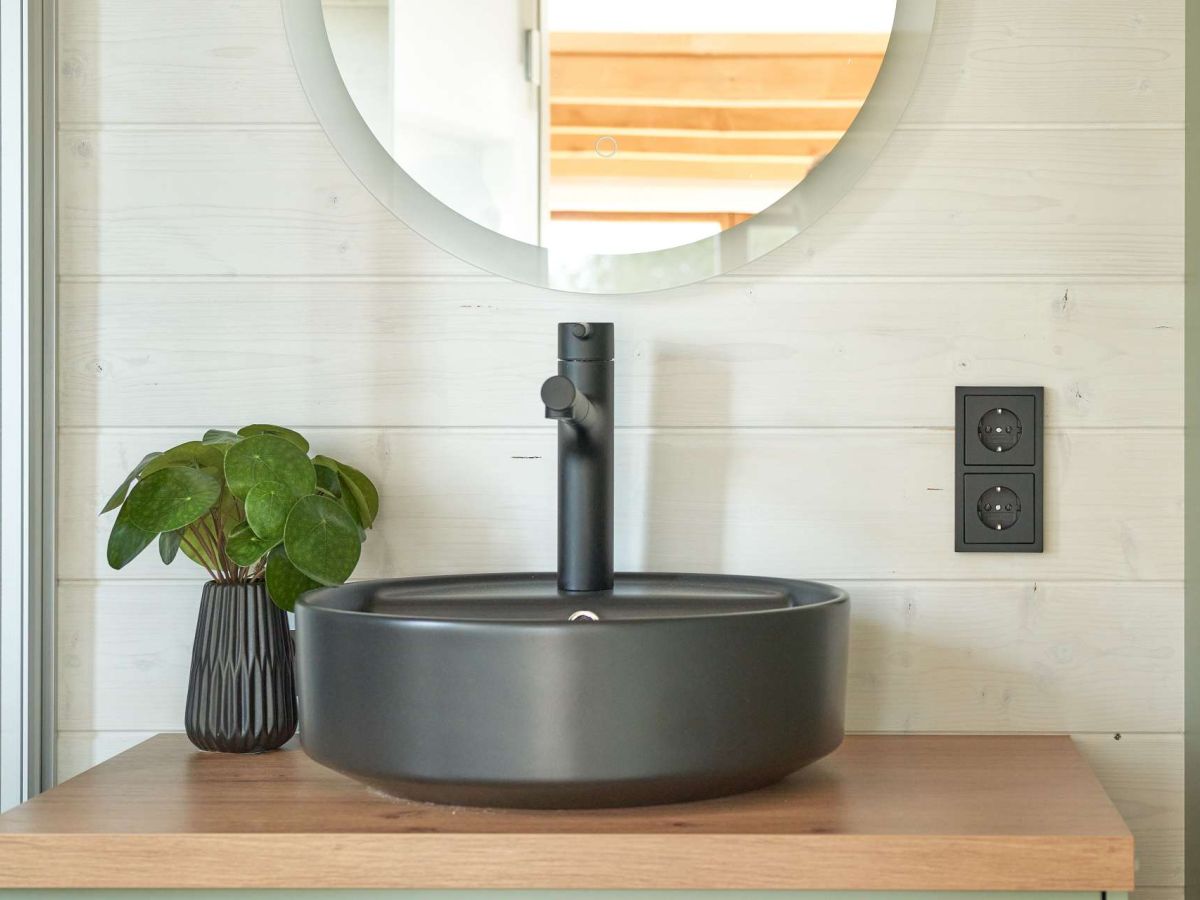 Waschbecken und runder Spiegel